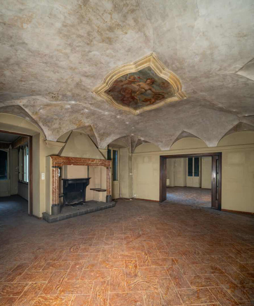 Salone di Casa Varenna a Locarno prima del restauro, con camino storico, volte e medaglione settecentesco affrescato dalla bottega degli Orelli.