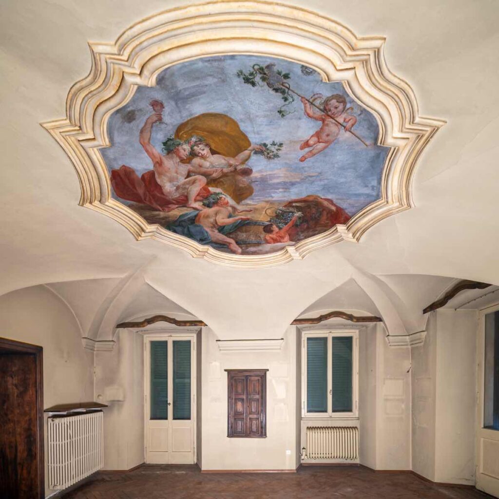 Salone storico di Casa Varenna a Locarno prima del restauro, con volte a crociera e dettaglio dell'affresco sul soffitto della bottega Orelli.